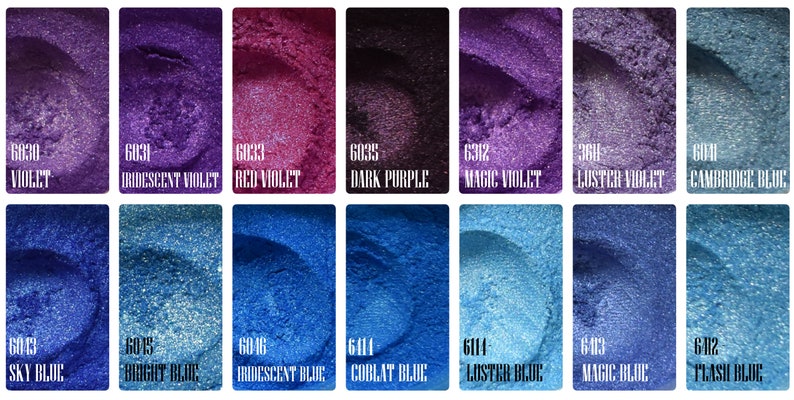 May include: A collection of shimmering cosmetic pigments in various shades of violet and blue. Each color is displayed in a rectangular container with a unique name and number, including "Violet," "Iridescent Violet," and "Sky Blue."