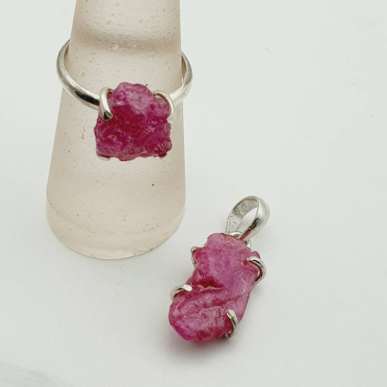 Peut inclure: Un ensemble de deux bagues en argent avec des pierres pr&eacute;cieuses en rubis brut. Le rubis est de couleur rose fonc&eacute; et a une texture brute et naturelle. Les bagues sont simples et &eacute;l&eacute;gantes.