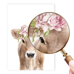 May include: A close-up of a brown calf wearing a pink flower crown. The calf's eye is magnified by a magnifying glass, revealing the intricate details of its fur.