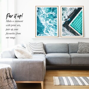 May include: Two framed prints of aerial ocean photography. The left print shows a turquoise ocean with white waves. The right print shows a turquoise pool with a white border, surrounded by turquoise water. The text "Pair it up! Make a statement with print sets, pair up your favourites from our range." is visible below the prints.