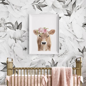 May include: A brown calf with a pink flower crown on a white background with black and white floral wallpaper.