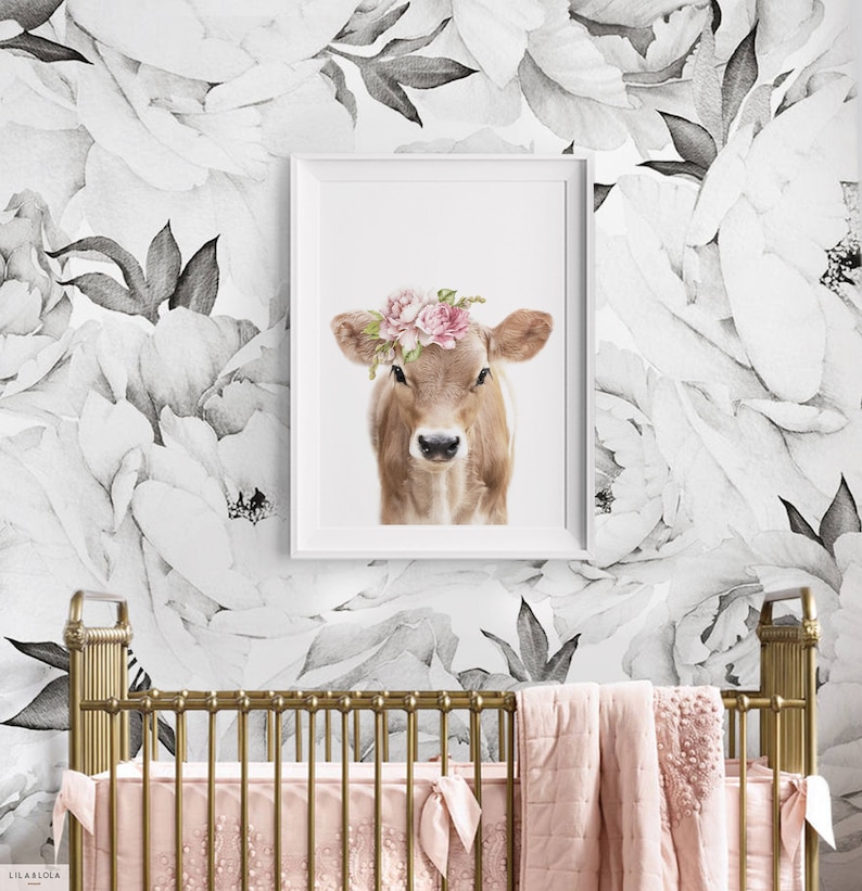 May include: A brown calf with a pink flower crown on a white background with black and white floral wallpaper.