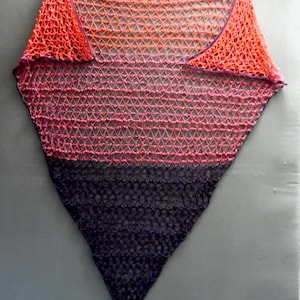 May include: A triangular crocheted shawl with a gradient of orange, pink, and purple.