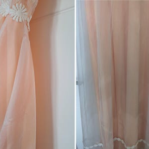K&ouml;nnte beinhalten: Ein pfirsichfarbenes Vintage-Nachthemd mit einem transparenten Overlay. Das Oberteil hat wei&szlig;e florale Spitzentrimm. Der Stoff drapiert sich weich und erzeugt eine flie&szlig;ende Silhouette. Das Nachthemd ist wahrscheinlich aus leichtem Material.