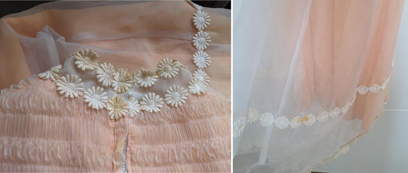 K&ouml;nnte beinhalten: Ein vintage pfirsichfarbenes Kleid mit zarten G&auml;nsebl&uuml;mchen-Details. Das Oberteil hat ein ger&uuml;schtes Design und wei&szlig;e G&auml;nsebl&uuml;mchen-Applikationen. Der Rock hat einen transparenten &Uuml;berzug mit G&auml;nsebl&uuml;mchen-Bord&uuml;re.