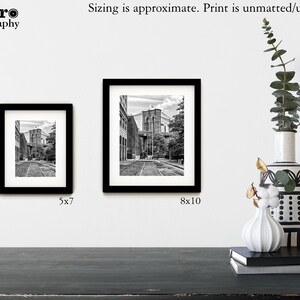 May include: Two black framed photographs of a black and white image of a street in New York City with the Brooklyn Bridge in the background. The smaller photo is 5x7 inches and the larger photo is 8x10 inches.