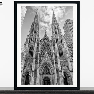 May include: A black and white photograph of a large, ornate church with two tall spires. The church is located in a city and is surrounded by other buildings.