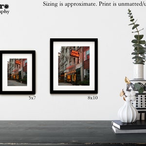 May include: Two framed photographs of a city street scene with a neon sign that reads "Wines Liquors". The smaller photo is 5x7 inches and the larger photo is 8x10 inches.