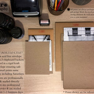 May include: A close-up of a wooden table with brown envelopes and a camera. The text "MCaro Photography" is at the top of the image. The text "All prints are always packaged and ready for gift giving! Mark the purchase as a gift during checkout & I will include a note from you to your recipient!" is on the right side of the image. The text "1 place 5x7, 8x10, 11x14, 11x17 prints in an acid free envelope in between 2 chipboard backers & are mailed in a rigid kraft photo envelope ensuring safe delivery. I mail prints same to next day including Saturdays. Larger prints are professionally packaged & mailed directly to you from my professional printing service & are mailed usually from 1-2 business days." is on the left side of the image. The text "* Prints shown are for reference only." is at the bottom of the image.