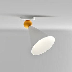 May include: A white cone-shaped ceiling light fixture with a round, orange accent. The light is mounted to the ceiling and points downwards.