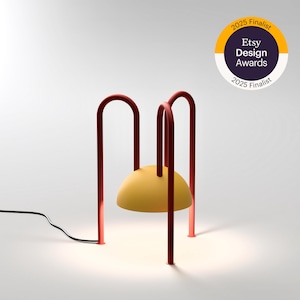 Moderne geometrische tafellamp ALLUGI van Balance Lamp met gele bol en rode poten