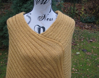 Peut inclure: Un châle en tricot jaune moutarde avec un col en V et un motif diagonal.