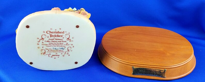 以下が含まれることがあります： 木製の台座の上に座っているテディベアファミリーのセラミック製フィギュア。台座には、「Cherished Teddies Annual Birthday Collection, Brittany, Colby, Danny and Rose "To the Best" And Five Cherished Friends A Hand-Painted Limited Edition by The Bradford Exchange.  #1790 "The Best" Collection 2003.」という銘板が取り付けられています。
