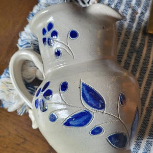 Salt glazed pitcher in cobalt blue leaf and flower design stoneware pottery, unmarked
