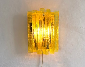 A yellow sconce designed by Claus Bolby