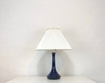 A blue glass desk lamp by Lisbeth Brams for Fog & Morup with a hand-pleated Le Klint shade
