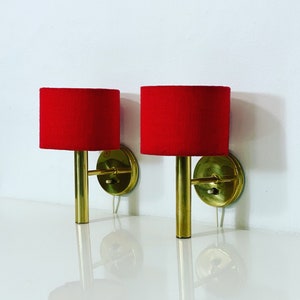 A pair of brass sconces by Svend Mejlstrom with red fabric shades | 1970s | Denmark