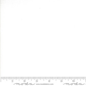 May include: A plain white fabric swatch with a ruler at the bottom. The ruler is marked in inches and has the text "moda" at the 2-inch mark and the 6-inch mark. The text "www.modafabrics.com" is printed below the ruler.