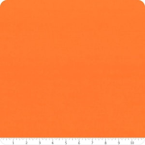 May include: Solid orange fabric with a ruler along the bottom edge. The fabric is a vibrant shade of orange, and the ruler shows measurements in inches.