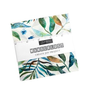 Puede incluir: Un cuadrado de tela blanco con un patrón de acuarela de hojas azules, verdes y marrones. La tela está etiquetada como "Wanderlust Create Joy Project" por Moda Fabrics.