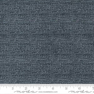 May include: A dark blue fabric with a subtle white grid pattern. The fabric has a textured, woven look. The fabric is measured with a ruler in inches.