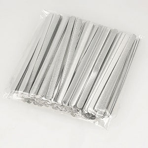 May include: A clear plastic bag filled with a large quantity of silver metal nose wire for face masks. The nose wire is flat and has a textured surface.
