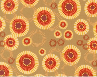 May include: A brown fabric with a repeating pattern of yellow, red, and orange circles with a radiating design. The fabric has a ruler with the word "moda" printed on it.