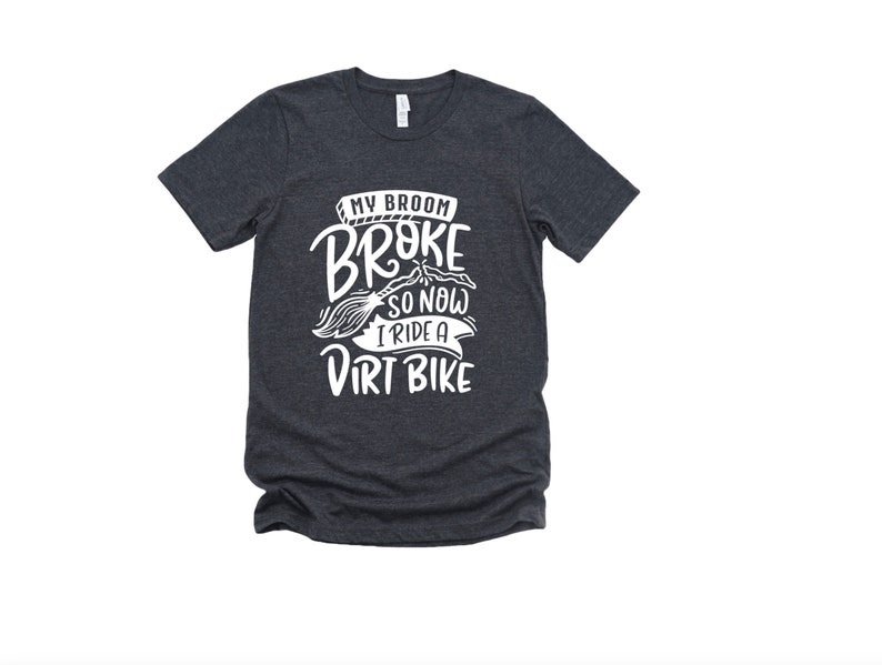 May include: Dark heather grey t-shirt with white text that reads "My broom broke so now I ride a dirt bike".