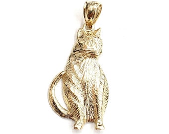 May include: A gold-colored cat pendant charm. The cat is sitting with its tail curled around its body. The pendant is detailed with a textured surface.
