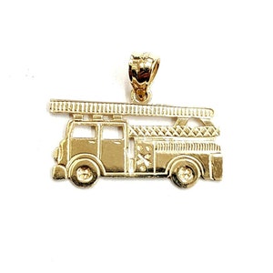 May include: A gold-colored fire truck pendant charm. The charm is detailed with a ladder, wheels, and a textured body.