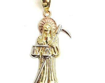 May include: A gold pendant featuring a detailed depiction of the Grim Reaper holding a scale and a scythe. The pendant is made of two-tone gold, with the figure being yellow gold and the scythe and scale being white gold.