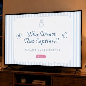 May include: A television screen displaying a game titled Who Wrote That Caption? for Hannah's Bachelorette. The screen features a light blue and white striped background, a diamond ring icon, a heart icon, a thumbs-up icon, and a pink Play button.