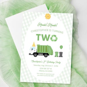 Op de afbeelding: Een rechthoekige verjaardagsuitnodiging met een lichtgroene vichy-ruitrand. De tekst luidt: Honk! Honk! CHRISTOPHER IS TURNING TWO. Het bevat een groene vuilniswagen met een feesthoedje, een zon en twee afvalcontainers met een groene ballon.