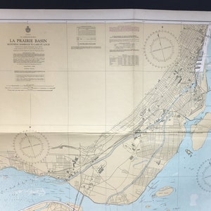 May include: A vintage nautical chart of La Prairie Basin, Montreal Harbour to Lake St. Louis. The chart shows the waterways, islands, and surrounding land features. It includes compass roses and depth soundings.
