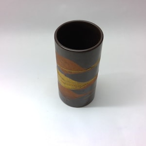 May include: A brown ceramic vase with a decorative design of gold and orange stripes.