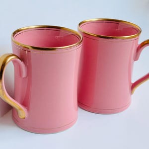 Pu&ograve; includere: Due tazze in ceramica rosa con bordo dorato. Le tazze hanno un design semplice e sono perfette per l'uso quotidiano.