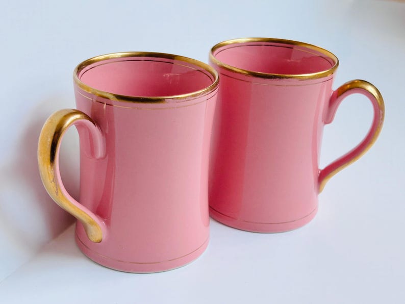Pu&ograve; includere: Due tazze in ceramica rosa con bordo dorato. Le tazze hanno un design semplice e sono perfette per l'uso quotidiano.