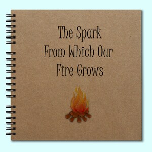 May include: A brown spiral bound journal with the text "The Spark From Which Our Fire Grows" and a drawing of a campfire with orange flames.