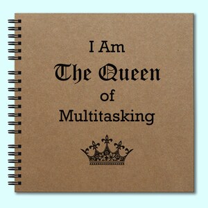 May include: Spiral-bound notebook with a kraft paper cover. The cover features the text "I Am The Queen of Multitasking" in a decorative font, along with a crown illustration. The notebook has a black spiral binding.