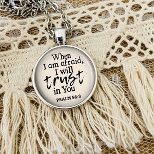 May include: A silver necklace with a round pendant featuring the text "When I am afraid, I will trust in You" and "PSALM 56:3".
