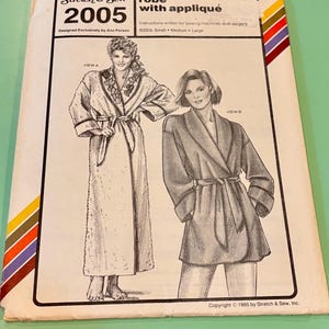 May include: A vintage sewing pattern titled "Stretch & Sew 2005" for a robe with appliqué. The cover features illustrations of the robe in two views, with text indicating sizes: Small, Medium, and Large. The pattern is designed by Ann Person.