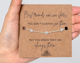 May include: A silver-toned chain bracelet featuring three small star charms, displayed on a rectangular brown card. The card includes the printed text: Best friends are like stars, you don't always see them, but you know they are always there.