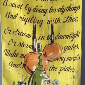 May include: Yellow kitchen towel with a vintage illustration of cooking utensils, a wine bottle, and flowers. The towel has a printed poem about cooking. The towel is held by a wooden clothespin.