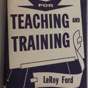 May include: A vintage book cover with a tan background and black text. The title is "Tools for Teaching and Training" with the author's name "LeRoy Ford" below. The cover features a stylized illustration of an easel.