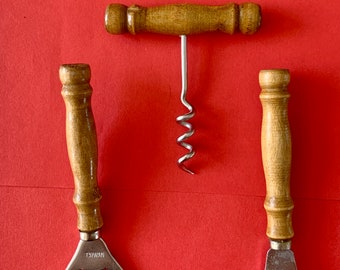 May include: A set of three kitchen tools with wooden handles. The tools include a corkscrew, a bottle opener, and a can opener. The tools are all made of metal and have a silver finish.