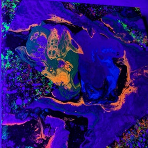 May include: Abstract painting with swirling patterns in shades of purple, blue, green, orange, and black. The painting has a vibrant, almost neon-like quality.