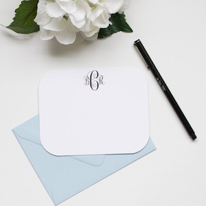May include: A white card with rounded corners and a blue envelope. The card has a monogram of the letters "BCR" in a script font.