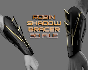May include: A 3D model file for a black and gold arm bracer with sharp edges and a textured surface. The text "ROBIN SHADOW BRACER 3D FILE" is displayed in the image.