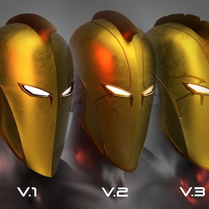 Puede incluir: Tres versiones de un casco dorado con una cresta puntiaguda y ranuras para los ojos blancas. Los cascos están etiquetados como V.1, V.2 y V.3.