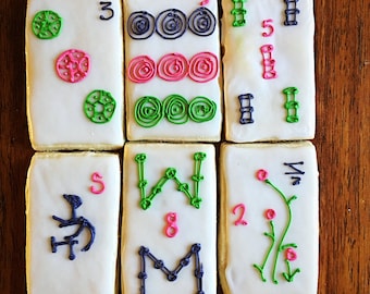 May include: Six white rectangular cookies decorated with colorful icing. The cookies feature numbers, letters, and symbols. The cookies are arranged in two rows of three.